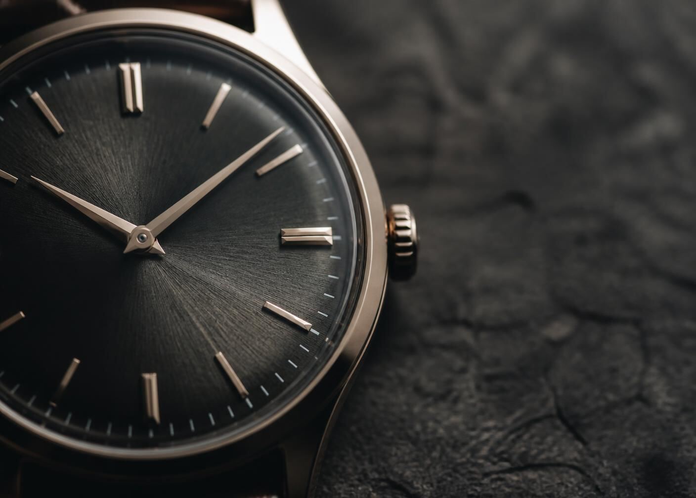 Macro photograph of a luxury watch dial with applied indices and fine sunburst texture